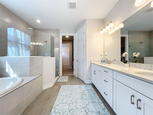 bathroom with shower with separate bathtub and vanity