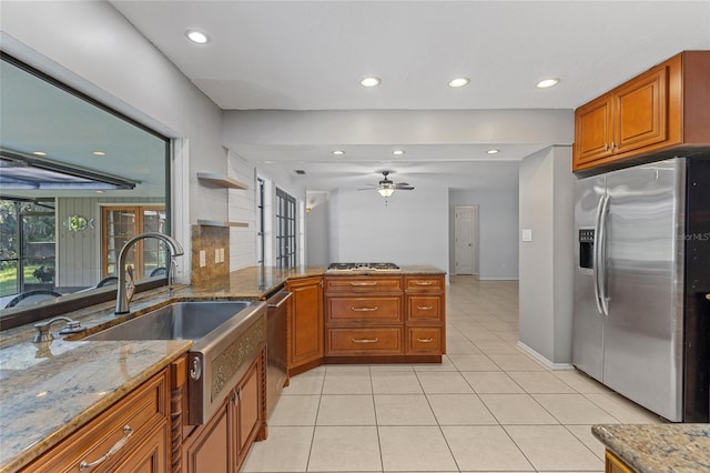 kitchen with ceiling fan, light stone countertops, appliances with stainless steel finishes, and light tile patterned floors