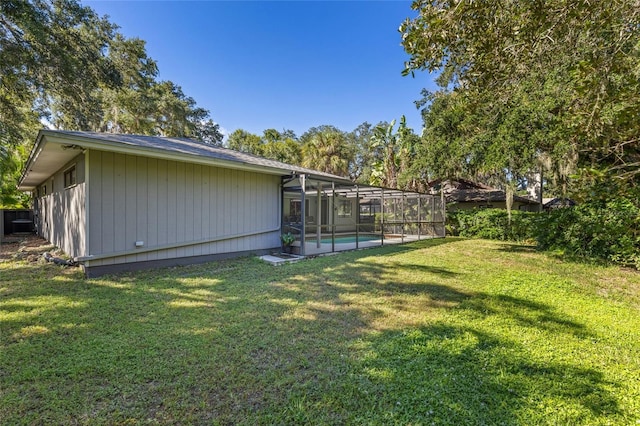 view of yard with a lanai and a fenced in pool