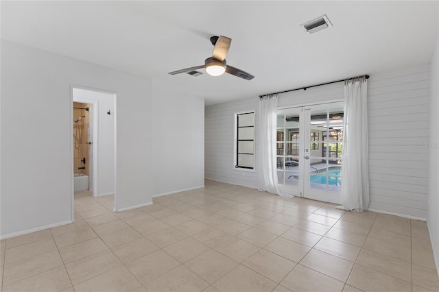 unfurnished room with light tile patterned flooring, ceiling fan, and french doors