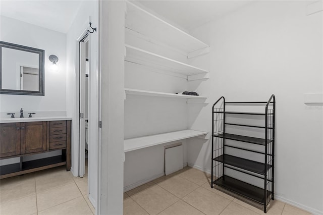 spacious closet with sink and light tile patterned floors