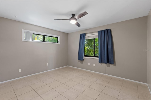 tiled spare room with ceiling fan