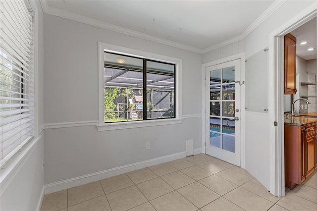 spare room with ornamental molding, plenty of natural light, and light tile patterned floors