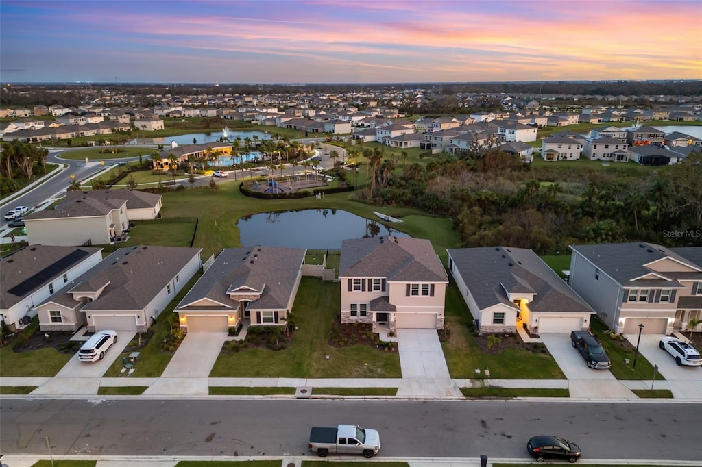 aerial view at dusk featuring a water view