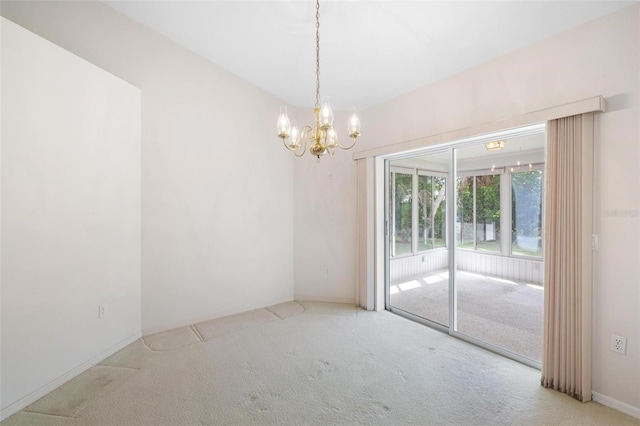 carpeted spare room with a chandelier