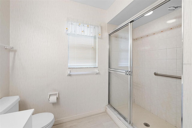 bathroom with a shower with door, vanity, and toilet