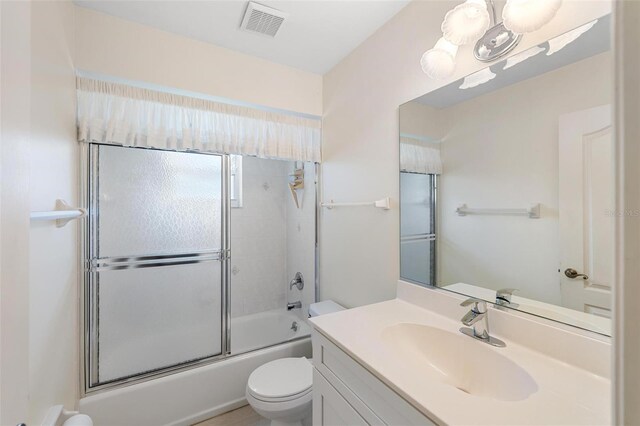 full bathroom featuring vanity, enclosed tub / shower combo, and toilet