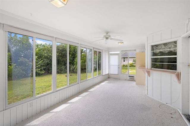 unfurnished sunroom with ceiling fan and a wall mounted air conditioner