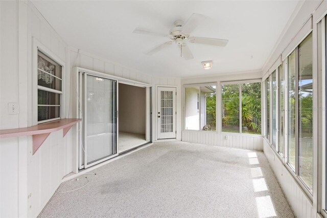 unfurnished sunroom with ceiling fan