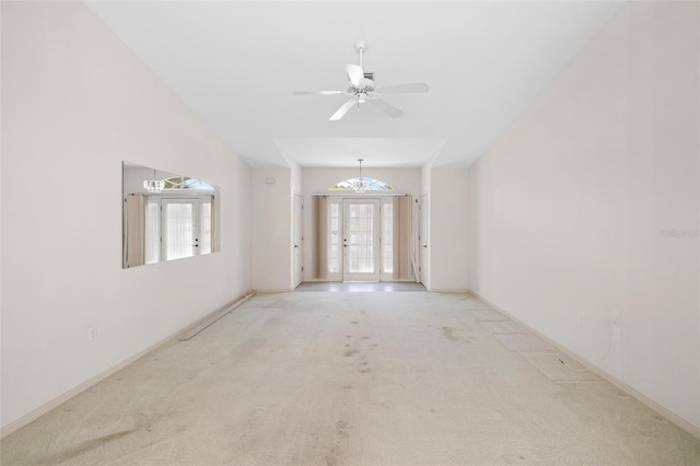 carpeted spare room featuring ceiling fan and french doors