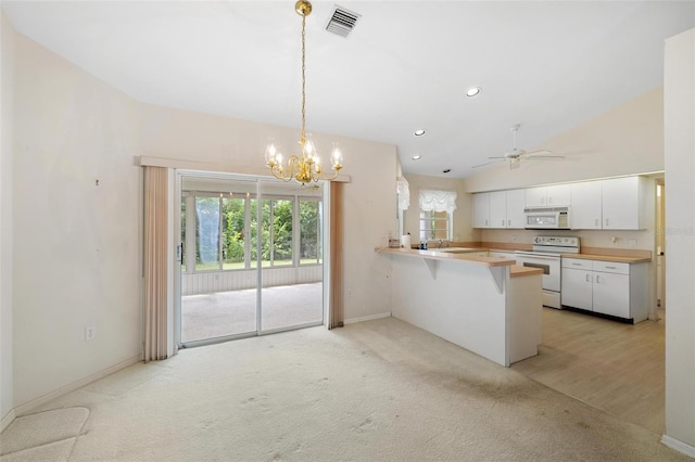 kitchen featuring white appliances, hanging light fixtures, white cabinets, light colored carpet, and kitchen peninsula