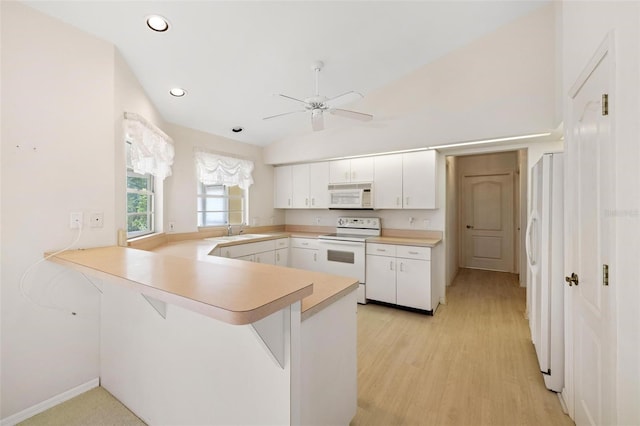 kitchen featuring white appliances, kitchen peninsula, sink, and white cabinets