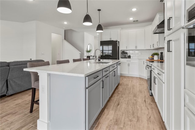 kitchen featuring white cabinets, appliances with stainless steel finishes, and a breakfast bar