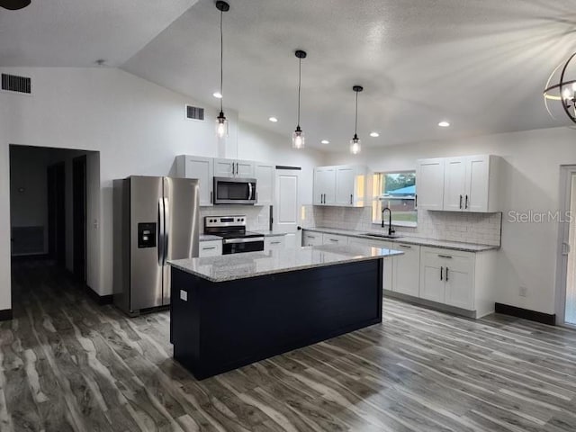 kitchen featuring white cabinets, sink, a kitchen island, appliances with stainless steel finishes, and vaulted ceiling