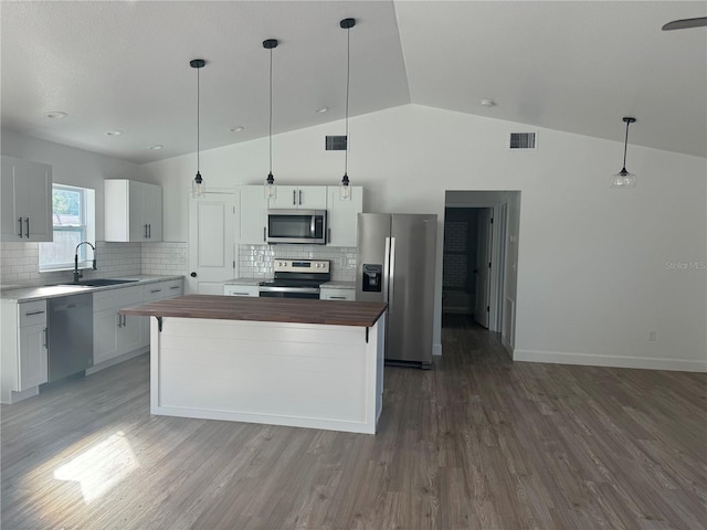 kitchen featuring stainless steel appliances, hanging light fixtures, sink, and butcher block counters