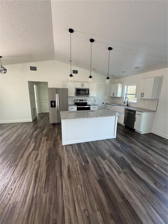 kitchen with white cabinets, stainless steel appliances, dark hardwood / wood-style floors, and pendant lighting