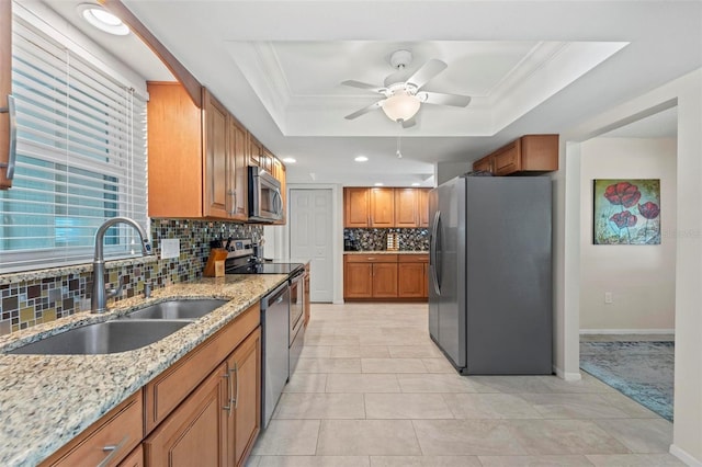 kitchen featuring appliances with stainless steel finishes, sink, tasteful backsplash, and a tray ceiling