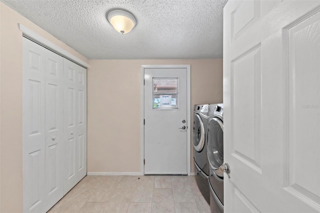 laundry area featuring a textured ceiling and washing machine and clothes dryer