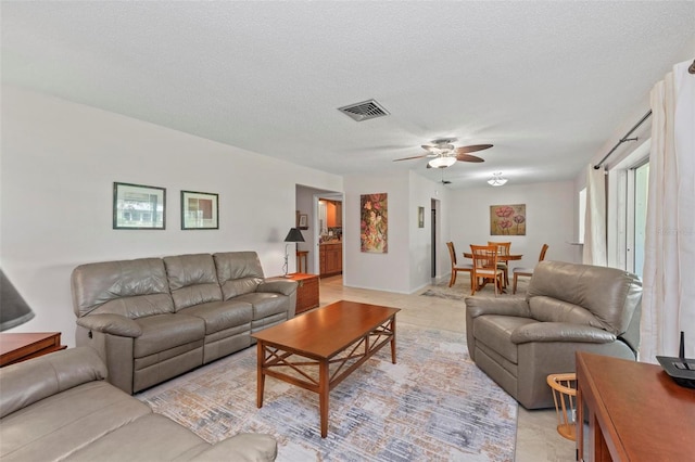 living room featuring a textured ceiling and ceiling fan