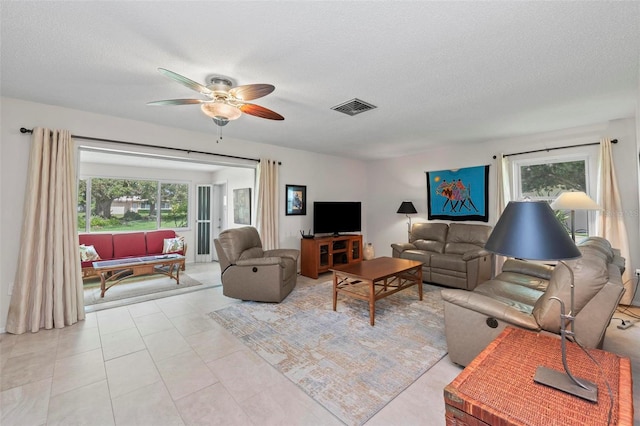 tiled living room featuring a textured ceiling and ceiling fan