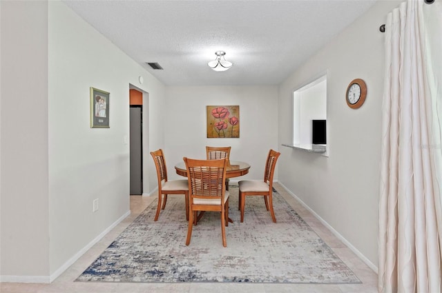 dining space featuring a textured ceiling