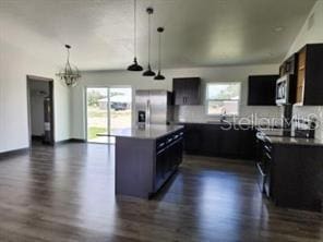 kitchen featuring stainless steel appliances, dark wood finished floors, a chandelier, and a healthy amount of sunlight