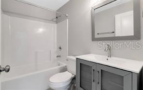 full bathroom with bathtub / shower combination, vanity, and toilet