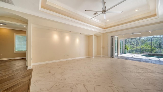 spare room featuring ceiling fan, a tray ceiling, and ornamental molding