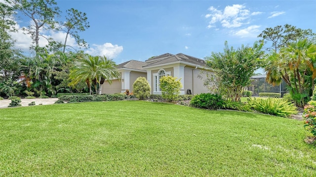 view of front of house with a front lawn and glass enclosure