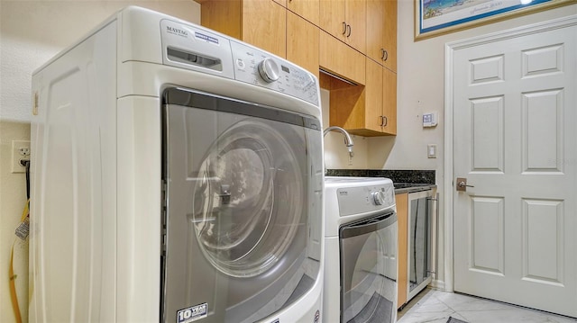 laundry room with separate washer and dryer and cabinets