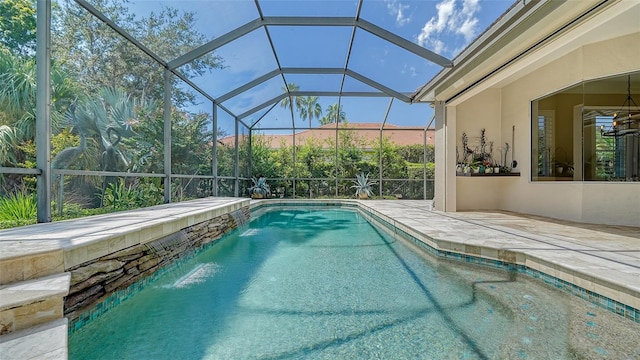 view of pool featuring pool water feature, glass enclosure, ceiling fan, and a patio area