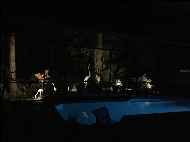 view of pool at twilight