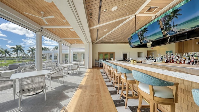 bar with wood ceiling, butcher block counters, high vaulted ceiling, and ceiling fan