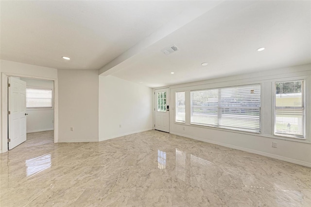 unfurnished room featuring beam ceiling and plenty of natural light