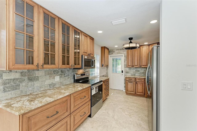 kitchen with appliances with stainless steel finishes, backsplash, and light stone counters