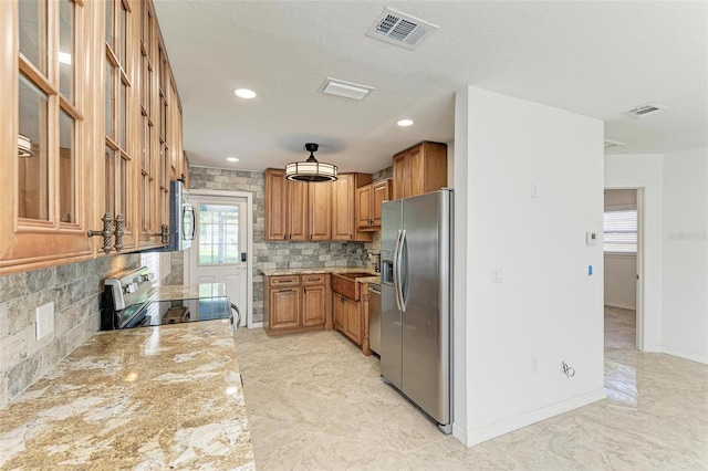 kitchen with sink, light stone countertops, a textured ceiling, appliances with stainless steel finishes, and tasteful backsplash