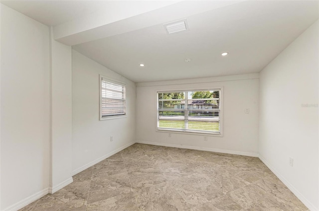 spare room featuring lofted ceiling