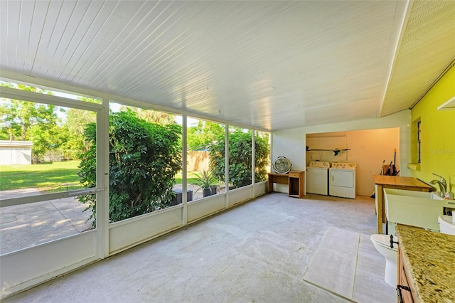 sunroom with washing machine and dryer, a healthy amount of sunlight, and lofted ceiling