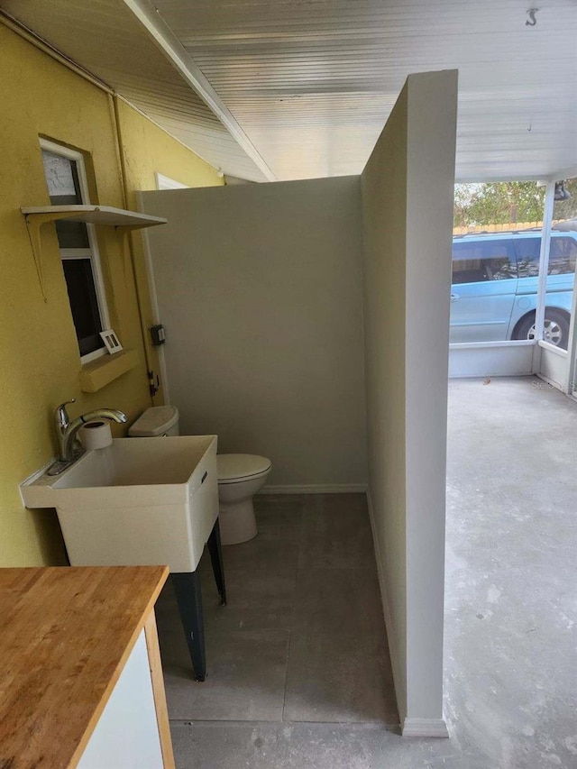 bathroom featuring concrete floors and toilet