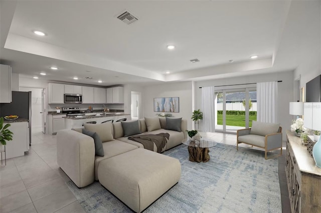 tiled living room with a tray ceiling and sink