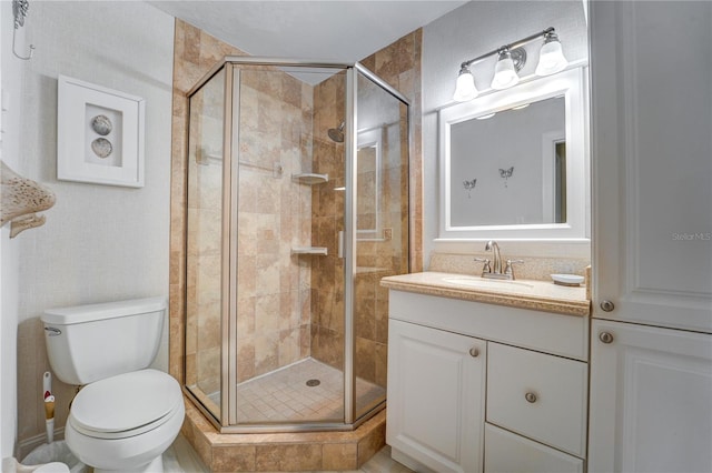 bathroom with vanity, a shower with shower door, and toilet