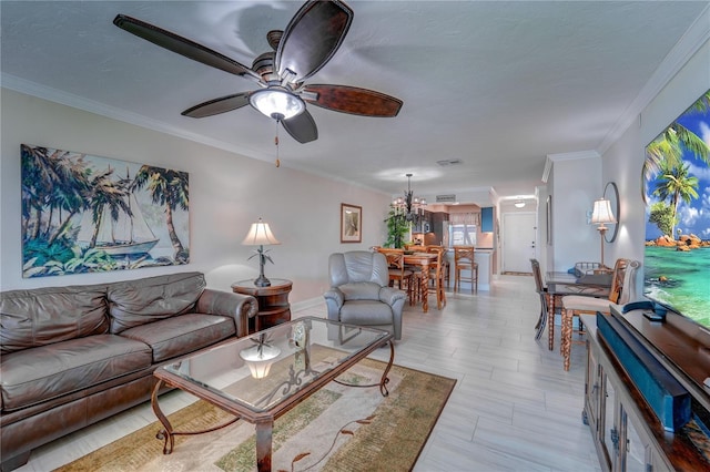 living room with ceiling fan with notable chandelier and crown molding