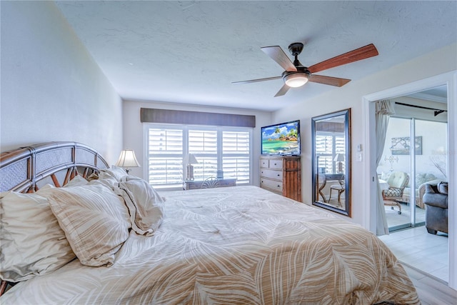 bedroom with a textured ceiling, access to outside, ceiling fan, and light hardwood / wood-style flooring