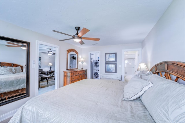 bedroom featuring visible vents, stacked washer / dryer, and a ceiling fan