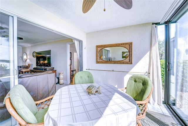 dining space with ceiling fan, a textured ceiling, and ornamental molding