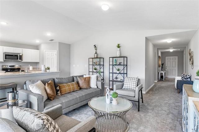 carpeted living room featuring lofted ceiling and sink