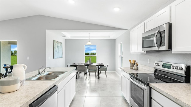 kitchen with lofted ceiling, appliances with stainless steel finishes, white cabinetry, and sink