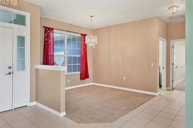 carpeted empty room with an inviting chandelier