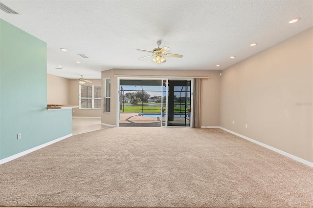 unfurnished living room with a textured ceiling, ceiling fan, and light colored carpet