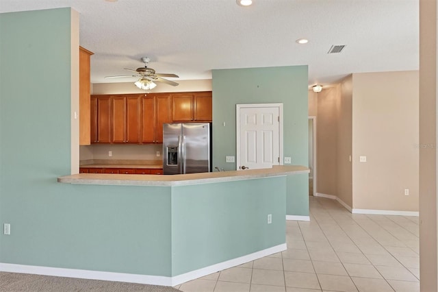 kitchen featuring light tile patterned flooring, kitchen peninsula, a textured ceiling, ceiling fan, and stainless steel fridge with ice dispenser